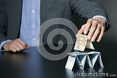 Businessman building financial pyramid from euro money Stock Photo