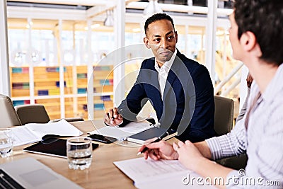 Businessman and businesswoman dicussing collaborative business in board room Stock Photo