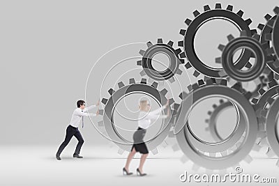 Businessman and businesswoman pushing gears Stock Photo