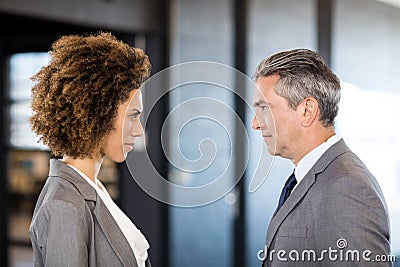 Businessman and businesswoman standing face to face Stock Photo