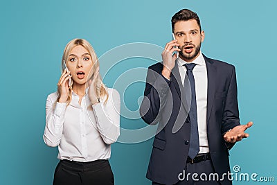 Businessman and businesswoman talking on smartphones on blue background Stock Photo