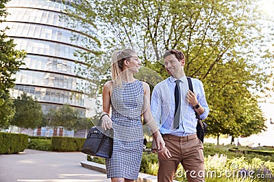 Businessman And Businesswoman Walk to Work Through City Park Stock Photo