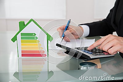 Businessman calculating energy efficiency rate at desk Stock Photo