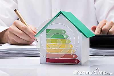 Businessman Calculating Energy Efficient House Stock Photo