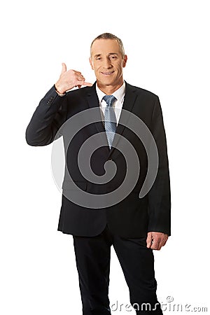 Businessman with call me gesture Stock Photo