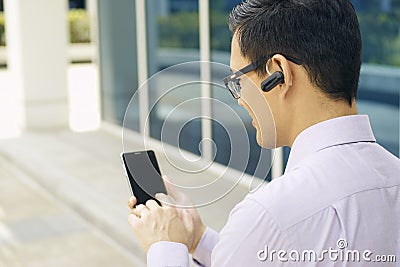 Businessman Calling On Mobile Phone With Bluetooth Handsfree Stock Photo