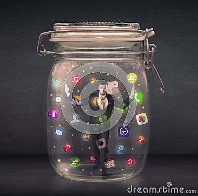 Businessman captured in a glass jar with colourful app icons con Stock Photo