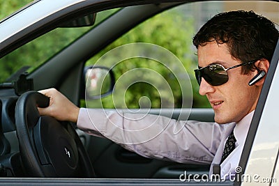 Businessman in car with blue-tooth Stock Photo