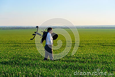 Businessman carries an office chair in a field to work, freelance and business concept, green grass and blue sky as background Stock Photo