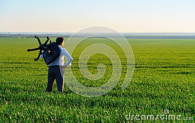 Businessman carries an office chair in a field to work, freelance and business concept, green grass and blue sky as background Stock Photo