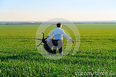 Businessman carries an office chair in a field to work, freelance and business concept, green grass and blue sky as background Stock Photo