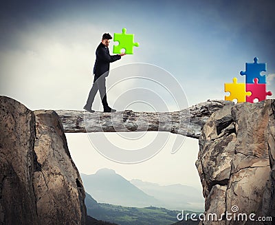 Businessman carries a piece of puzzle while he walking on a tree trunk. concept of missing piece Stock Photo