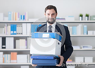 Businessman carrying a box and office folders Stock Photo