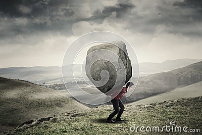 Businessman carrying rock at hill Stock Photo