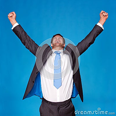 Businessman celebrating with arms raised in the air Stock Photo