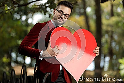 Businessman charged with emotions holding big red heart Stock Photo
