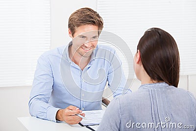 Businessman checking resume of female candidate during meeting Stock Photo