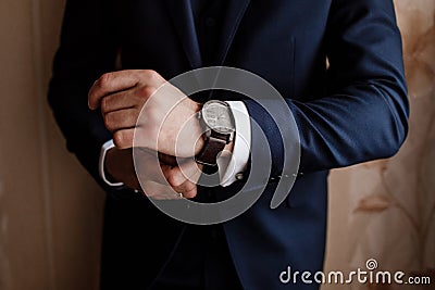 Businessman checking time on his wrist watch, groom getting ready in the morning before wedding ceremony Stock Photo