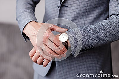 Businessman checking time on his wrist watch, groom getting ready in the morning before wedding ceremony Stock Photo