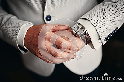 Businessman checking time on his wrist watch, groom getting ready in the morning before wedding ceremony Stock Photo