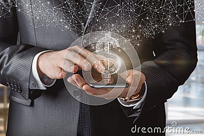 A businessman clicks on phones a hologram of a dollar sign appears Stock Photo