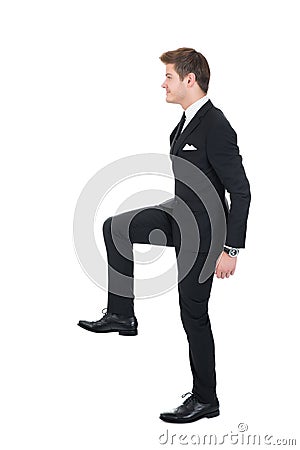 Businessman climbing imaginary steps Stock Photo