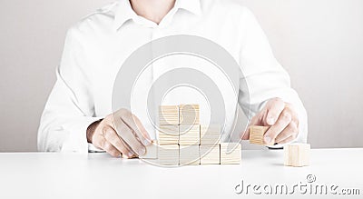 Businessman climbs the career ladder. Business concept from cubes Stock Photo