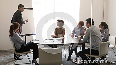 Businessman coach giving presentation on whiteboard at team business training Stock Photo