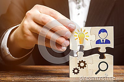 Businessman collects puzzles with the image of the attributes of doing business. Strategy planning concept. Organization of the Stock Photo