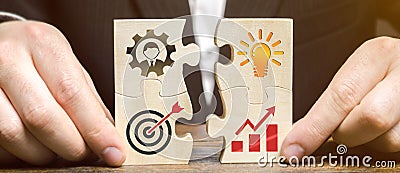 Businessman collects puzzles with the image of the attributes of doing business. Strategy planning concept. Organization of the Stock Photo