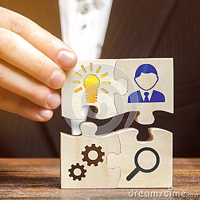 Businessman collects puzzles with the image of the attributes of doing business. Strategy planning concept. Organization of the Stock Photo