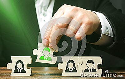 A businessman collects puzzles symbolizing a team of employees. The concept of creating a business team to perform tasks. Toxic Stock Photo