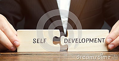 Businessman collects puzzles with the word Self-development. Concept of new business skills and motivation. Personal and career Stock Photo