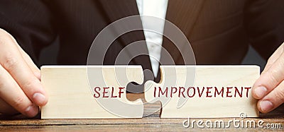 Businessman collects puzzles with the word Self-improvement. Concept of new business skills and motivation. Personal and career Stock Photo