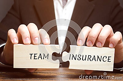 Businessman collects puzzles with the words Team Insurance. Security and safety in a business team. Care for employees. A Stock Photo