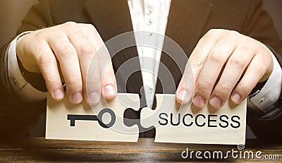 Businessman collects wooden puzzles Key to success. Concept of achieving the goal, overcoming difficulties, opportunities for Stock Photo