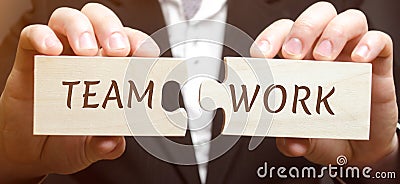 Businessman collects wooden puzzles with the word Teamwork. Joint achievement of a common goal. High efficiency and performance. Stock Photo