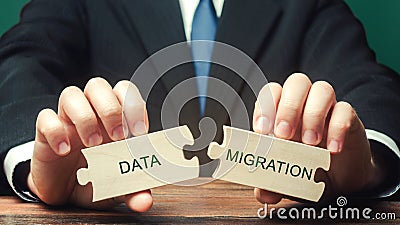 Businessman collects wooden puzzles with the words Data migration. Process of preparing, selecting, extracting data and Stock Photo