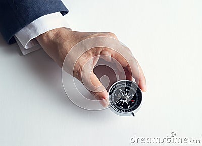 Businessman with a compass holding in hand on paper background Stock Photo