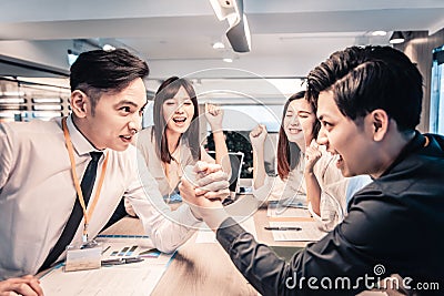 Businessman Competing In Arm Wrestling at office Stock Photo