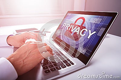 Businessman Configuring Privacy Settings In A Laptop Stock Photo