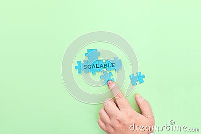 Businessman connecting puzzle pieces with the word Scalable Stock Photo