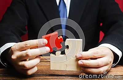 Businessman connects a red puzzle to the assembly. Business model planning and strategy, building a new one. Innovation Stock Photo