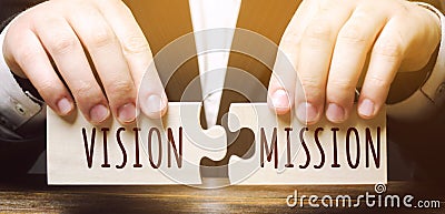 Businessman connects wooden puzzles with the words Vision Mission. Concept for business ideas and goals. Strategy development. Stock Photo