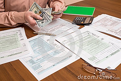 Businessman counting dollars of tax forms Editorial Stock Photo