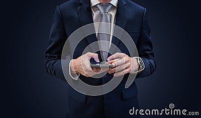 Businessman in dark blue suit using mobile smart phone, on blue background Stock Photo