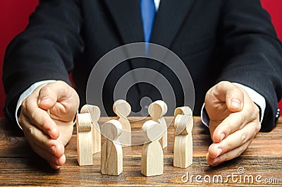 Businessman defending his team with a gesture of protection. Care for employees. Life insurance. Security and safety in a business Stock Photo