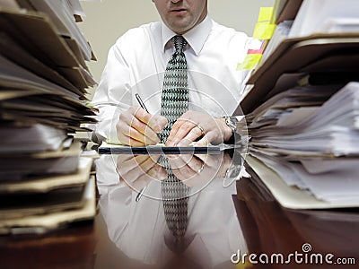 Businessman at Desk with Piles of Files Stock Photo