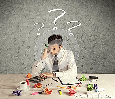 Businessman at desk with question mark Stock Photo