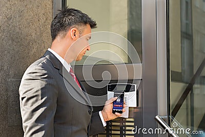 Businessman Disarming Security System Of Door With Smartphone Stock Photo